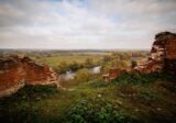Ceglane mury ruin na trawiastym wzgórzu nad doliną rzeki na Mazowszu
